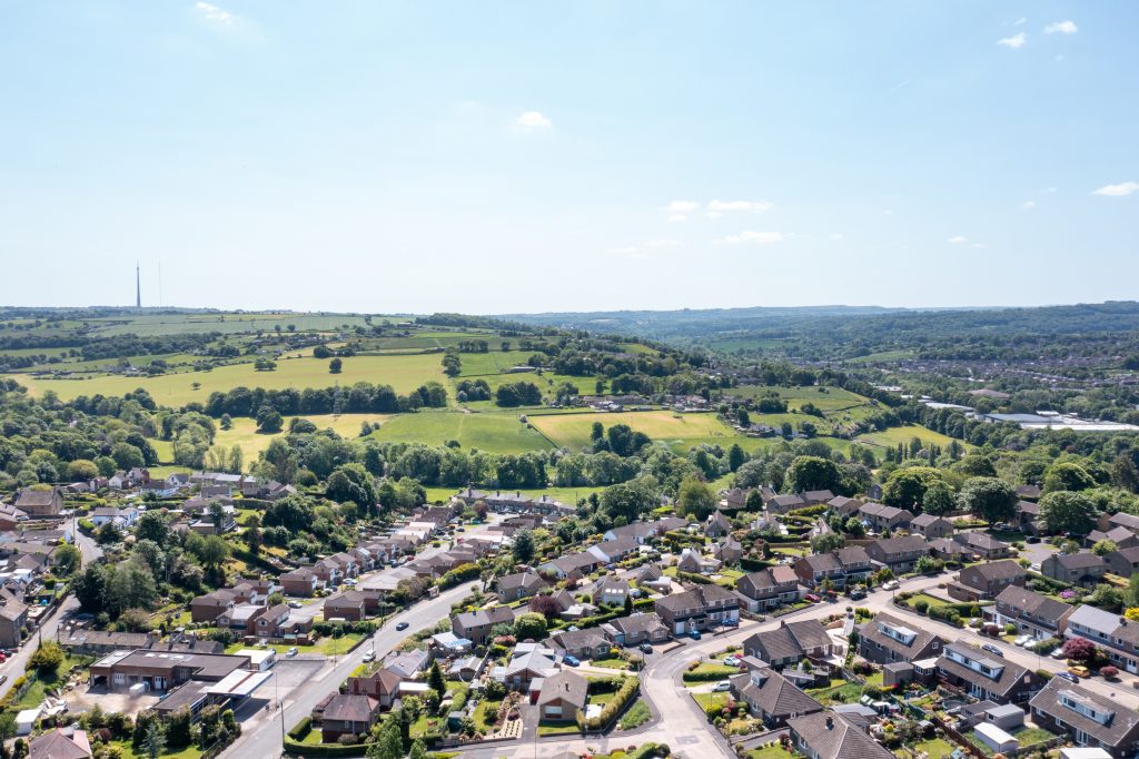 Aerial drone photo of the village of Kirkheaton, Huddersfield in the Kirklees district in the county of West Yorkshire England showing the village and River Calder from above in the summer time.